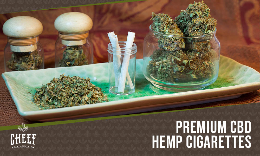 CBD Cigarettes featured blog image (shows CBD cigarettes in a jar with some CBD buds and ground flower nearby)