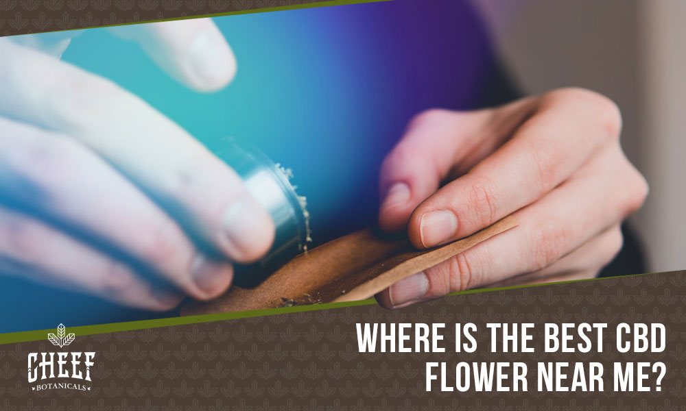 cbd flower near me (featured blog image by Cheef Botanicals) shows a person wrapping a CBD flower roll